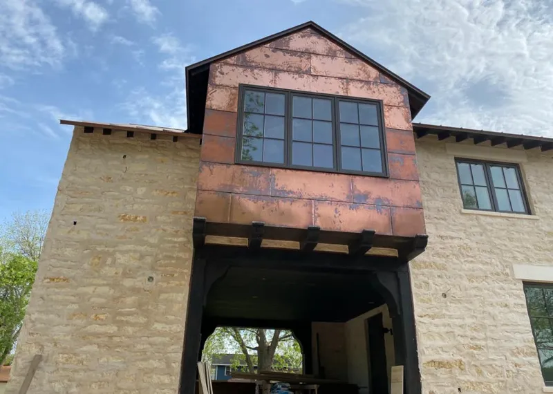 Copper metal panel facade on a stone building for Skylight Installation in Conway